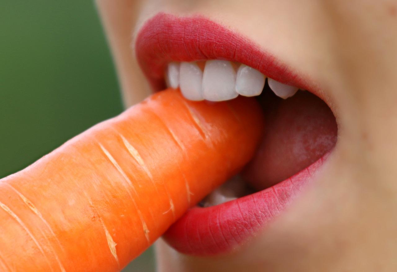 Woman eating carrot - Teeth Whitening Products
