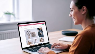 A hyper-realistic, professional photograph showing a creative small business owner in the UK, perhaps in a cosy workshop in Brighton or a modern studio in Manchester, smiling as they work on their vibrant and professional-looking WordPress website on a laptop. The website on screen should be clearly visible, showing a craft product or a portfolio. The lighting is soft and natural, creating a warm, aspirational, and trustworthy mood.