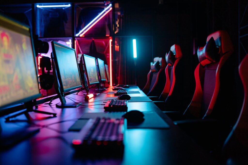 Online Gaming | Vacant leather gamer chairs in front of pro PC setups, ready for a team gaming session.