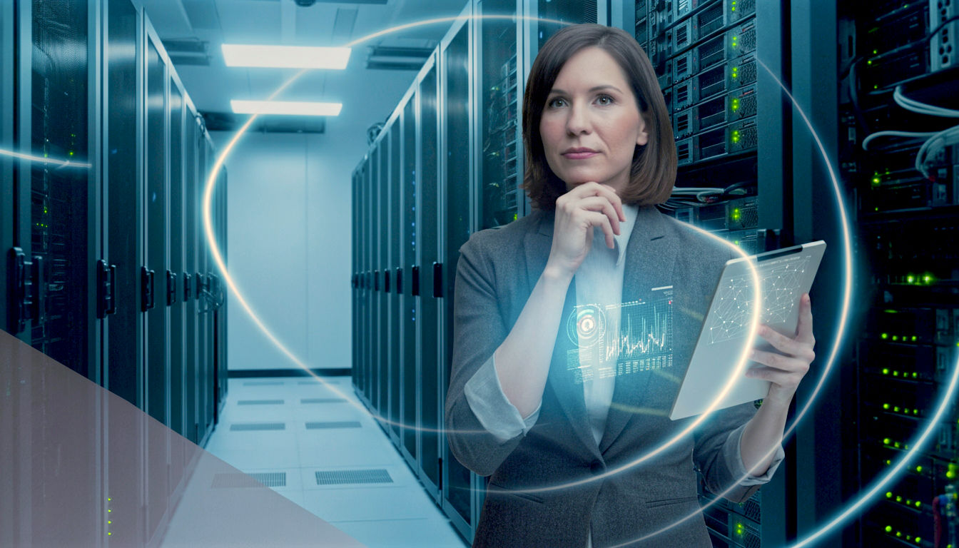 A hyper-realistic, professional photograph in the style of a modern tech publication. The image shows a clean, brightly lit server room with racks of sleek, black servers. Glowing blue and white LED lights create lines of light, suggesting the flow of data. In the foreground, slightly out of focus, is a British IT professional, a woman in her 30s with a thoughtful expression, holding a tablet displaying network graphs. The composition is a wide-angle shot that conveys scale, professionalism, and cutting-edge technology, with a subtle Union Jack graphic visible on a screen in the background to give it a UK context. The mood is clean, optimistic, and authoritative.