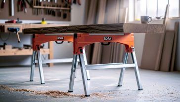 A hyper-realistic, professional photograph in the style of a workshop feature for a UK magazine. A pair of orange-body, silver legs, BORA Workhorse sawhorses are set up on a slightly dusty concrete floor in a well-lit British workshop. A single large, heavy-looking slab of English oak rests solidly across them. Sawdust is scattered on the floor, and in the soft-focus background, you can see woodworking tools hanging on a wall and a mug of tea sitting on a nearby bench. The lighting is bright but natural, coming from a large window, creating a mood of sturdy reliability and craftsmanship.